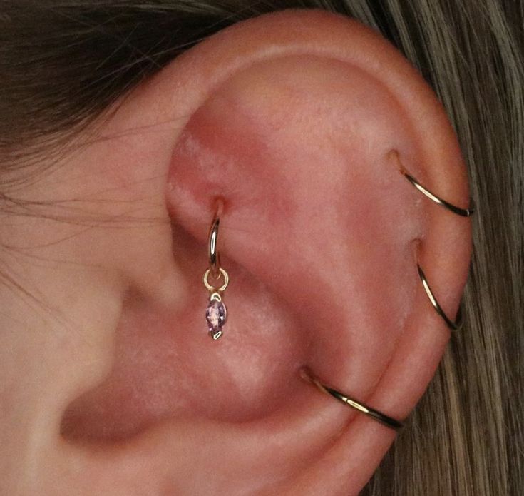 a close up of a person's ear with two different types of piercings