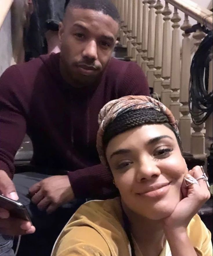 a woman sitting next to a man on the stairs