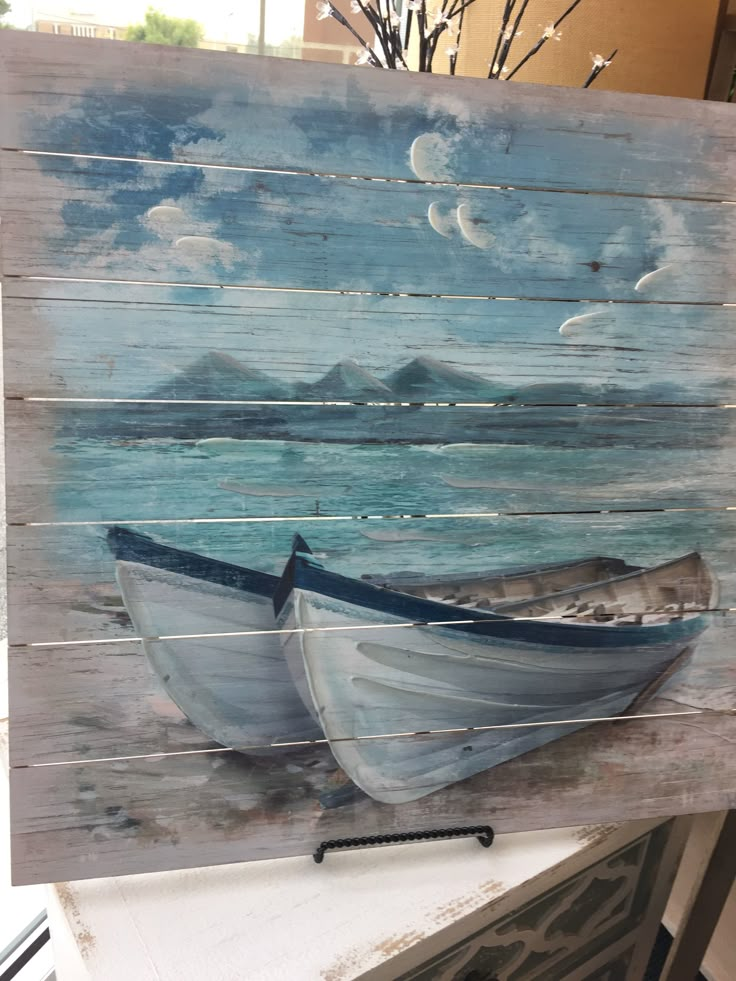 a painting of two boats in the water on a wooden board with white paint and some branches