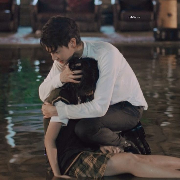 a man hugging a woman in the water while she is sitting on her lap and holding him