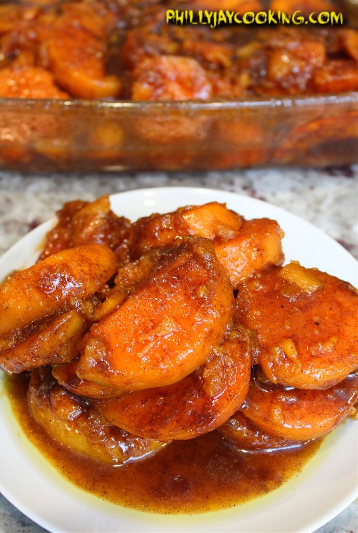 some food is on a white plate and next to a casserole dish filled with chicken wings