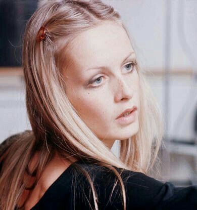 a woman with long blonde hair sitting down