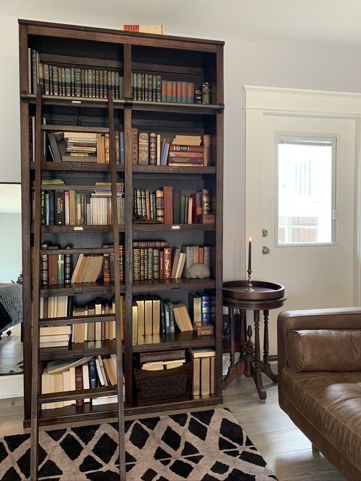 a living room filled with furniture and a book shelf full of books on top of it