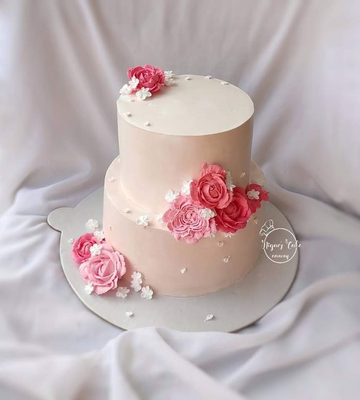 a three tiered cake with pink flowers on top