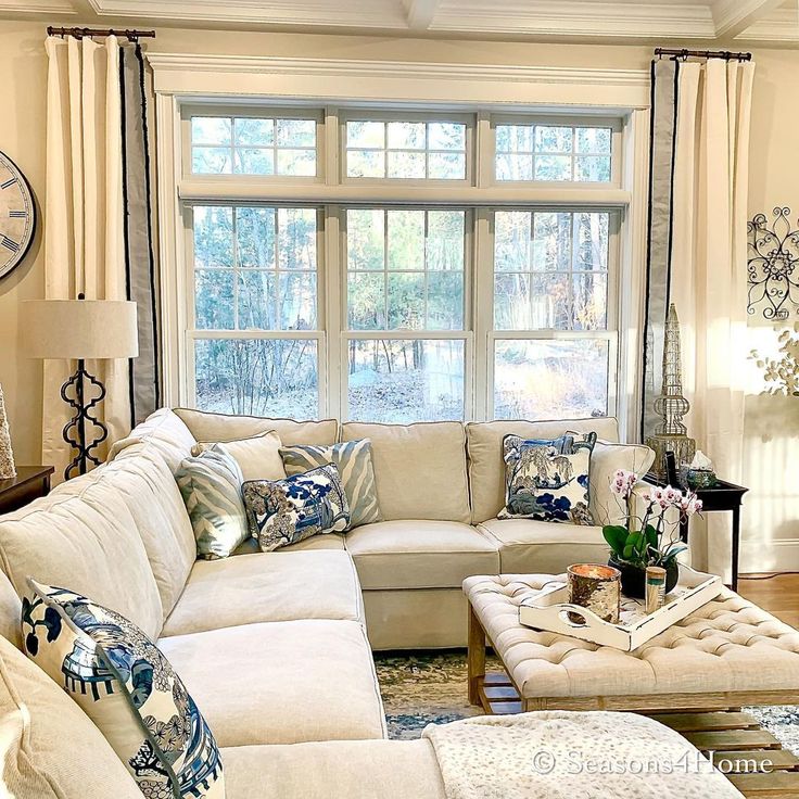 a living room filled with lots of furniture and a large clock on the wall above it