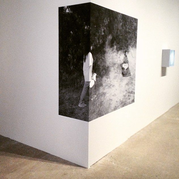 a black and white photo hanging on the side of a wall in an art gallery