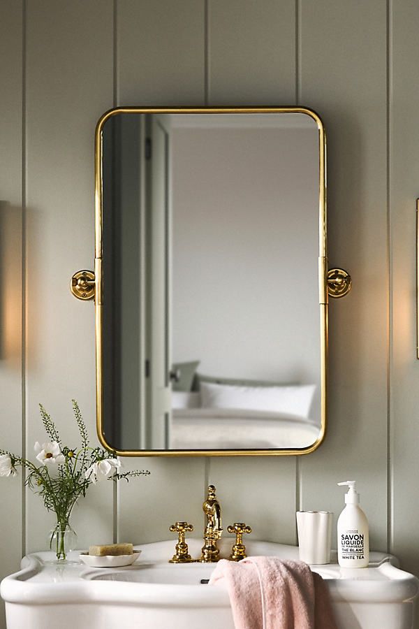 a bathroom sink with a mirror above it and a towel hanging on the wall next to it