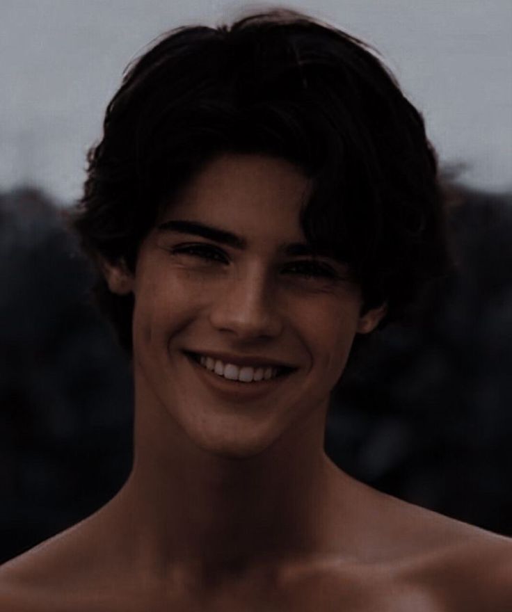 a shirtless young man smiling at the camera