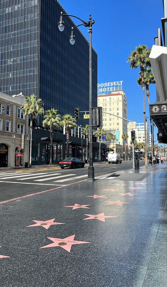 the hollywood walk of fame star is shown in front of tall buildings and palm trees