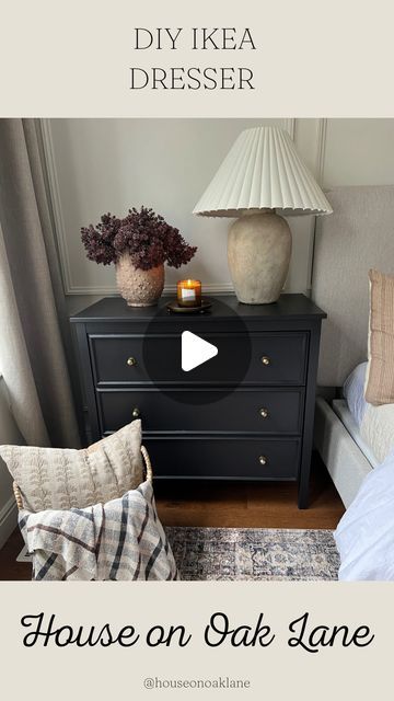 a black dresser sitting next to a bed in a bedroom