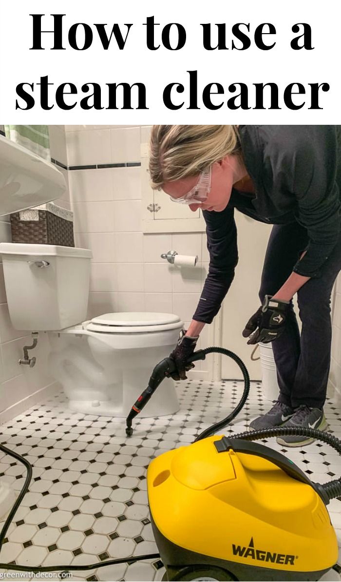 a woman is using a steam cleaner to clean a bathroom floor with a yellow and black vacuum