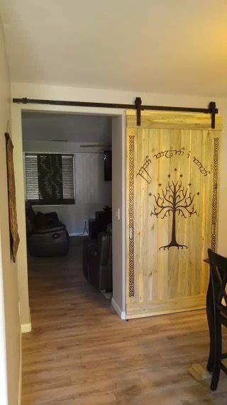 an open door leading to a living room with a tree design on the front and back doors