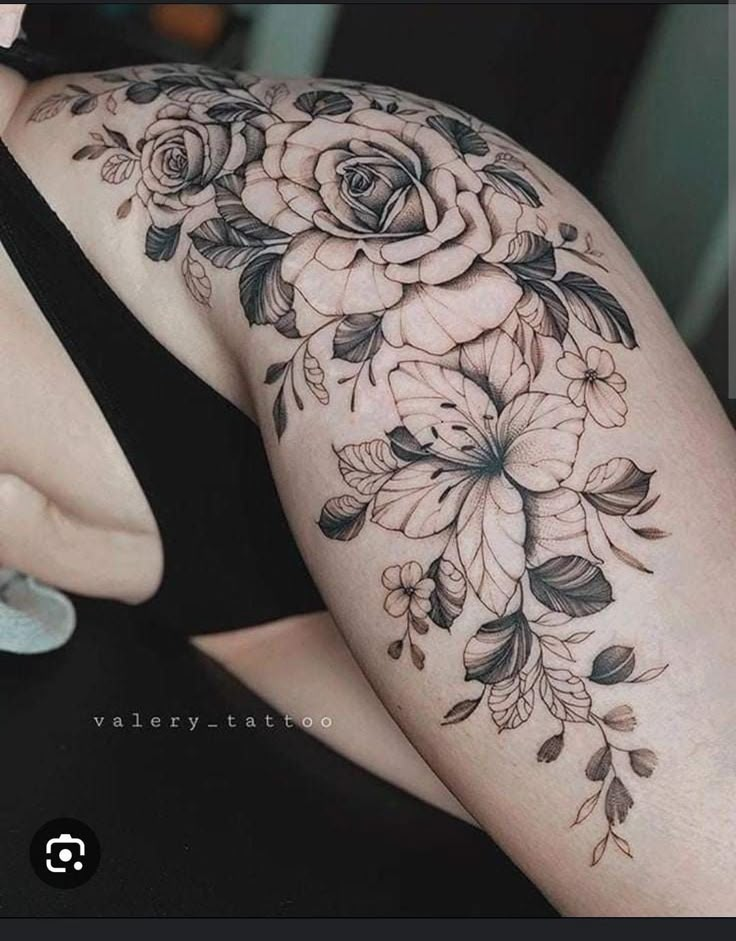 a woman's arm with flowers and leaves tattooed on the back of her body