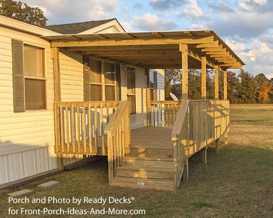 a mobile home with steps leading to the front porch and second story deck that overlooks an open field