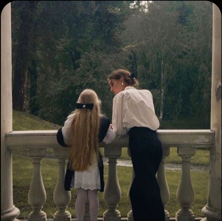 two women are standing on the porch with their backs to each other