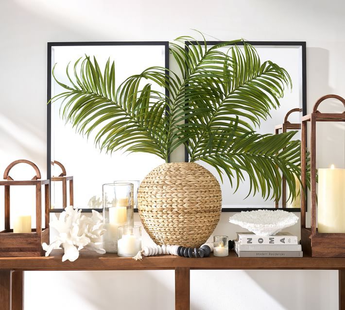 a wooden table topped with candles and a plant