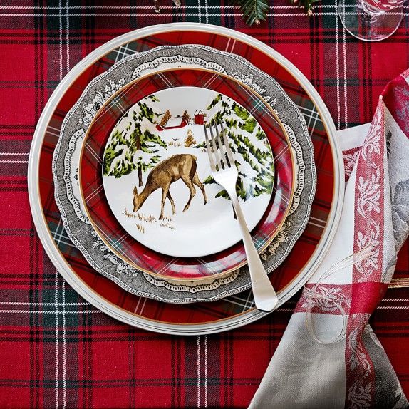 a christmas table setting with red plaid napkins and silverware