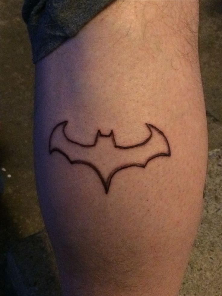 a man's leg with a batman symbol tattoo on the lower part of his calf