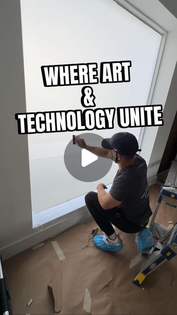 a man sitting on top of a step ladder in front of a white wall with the words where art and technology united