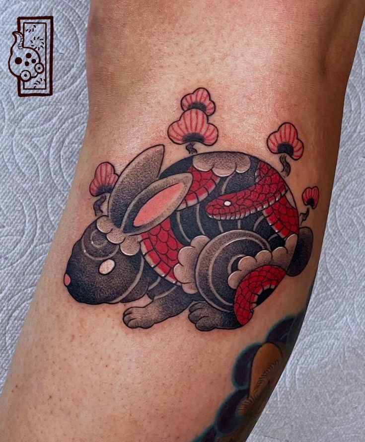 a close up of a person's leg with a tattoo design on the thigh