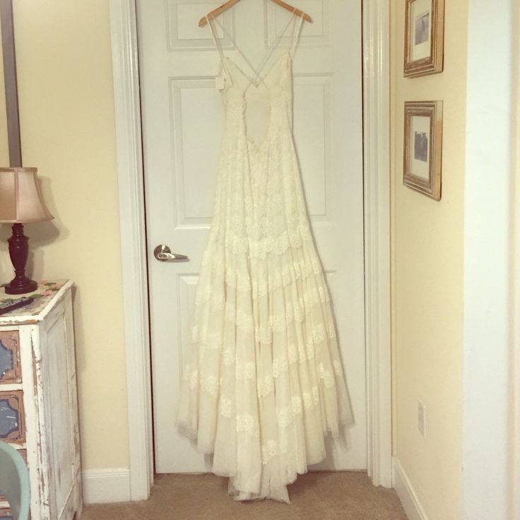 a white dress hanging on a door way