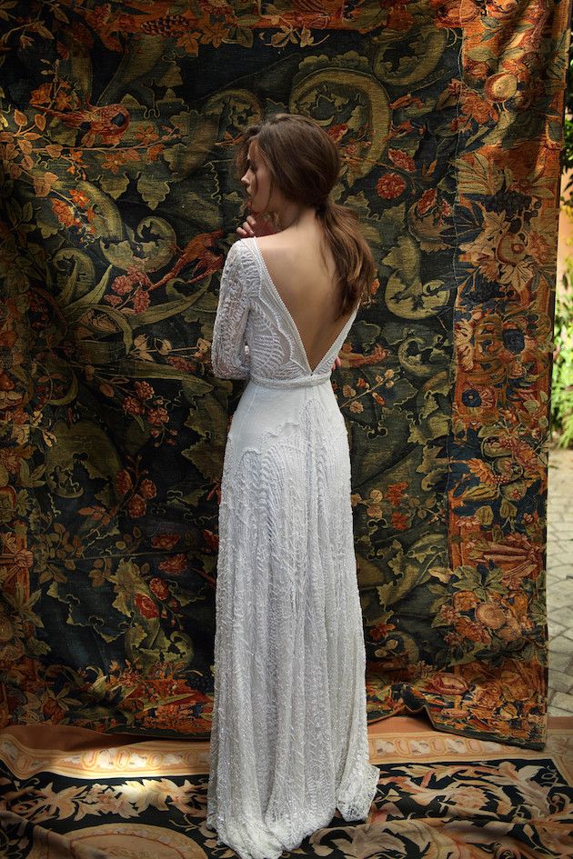 the back of a woman's dress in front of a tapestry