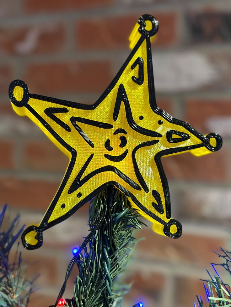 a yellow star ornament hanging from a christmas tree