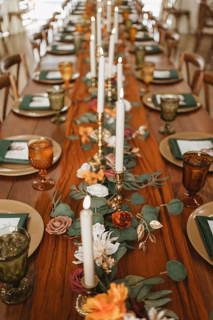 a long table with candles and flowers on it is set up for an elegant dinner