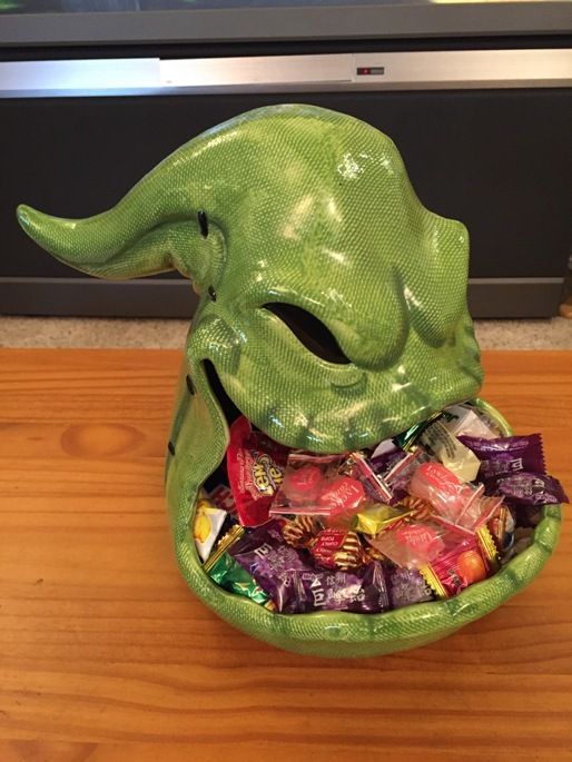 a green bowl filled with assorted candy