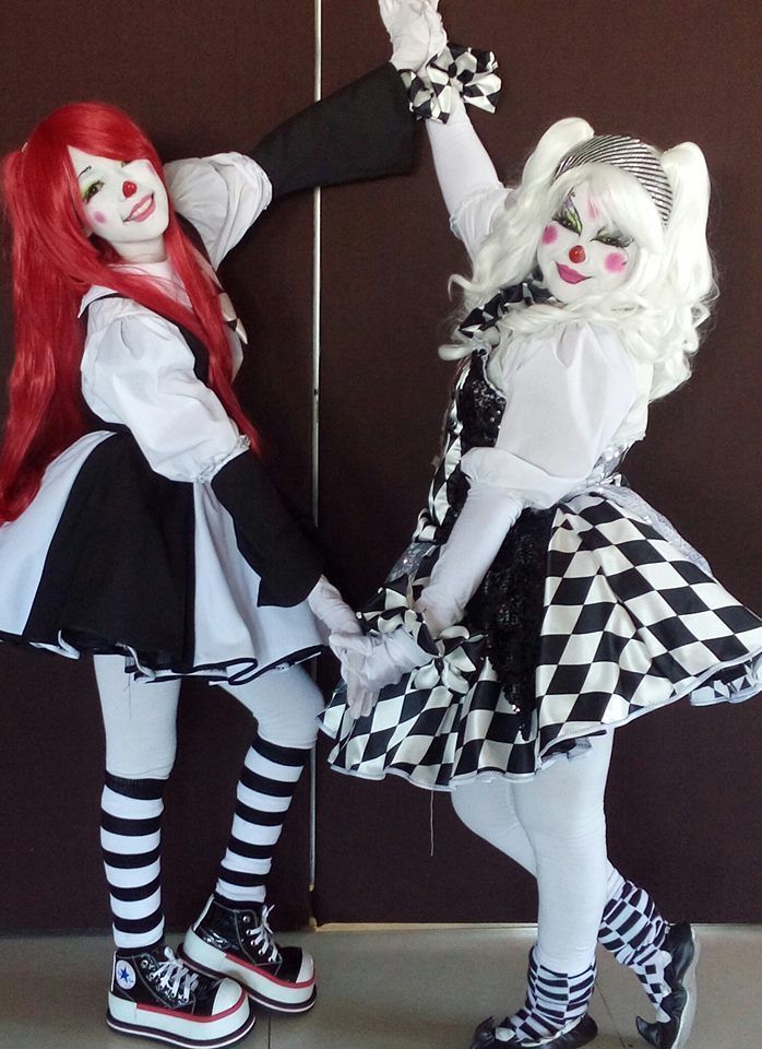 two dolls dressed in costumes holding hands