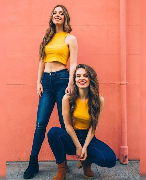 two women posing for a photo in front of a pink wall with the caption twin - melody