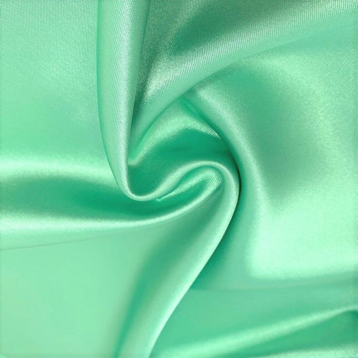 a close up shot of a green satin fabric