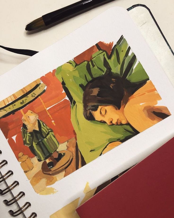 an open notebook with a drawing of a woman sleeping on top of it next to a pen