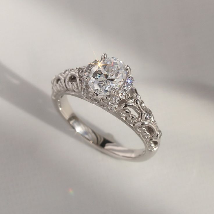 a diamond ring with filigrees on the sides