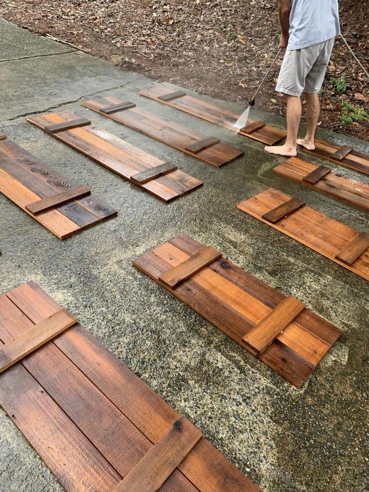 a man standing on top of a wooden floor next to a pile of wood planks