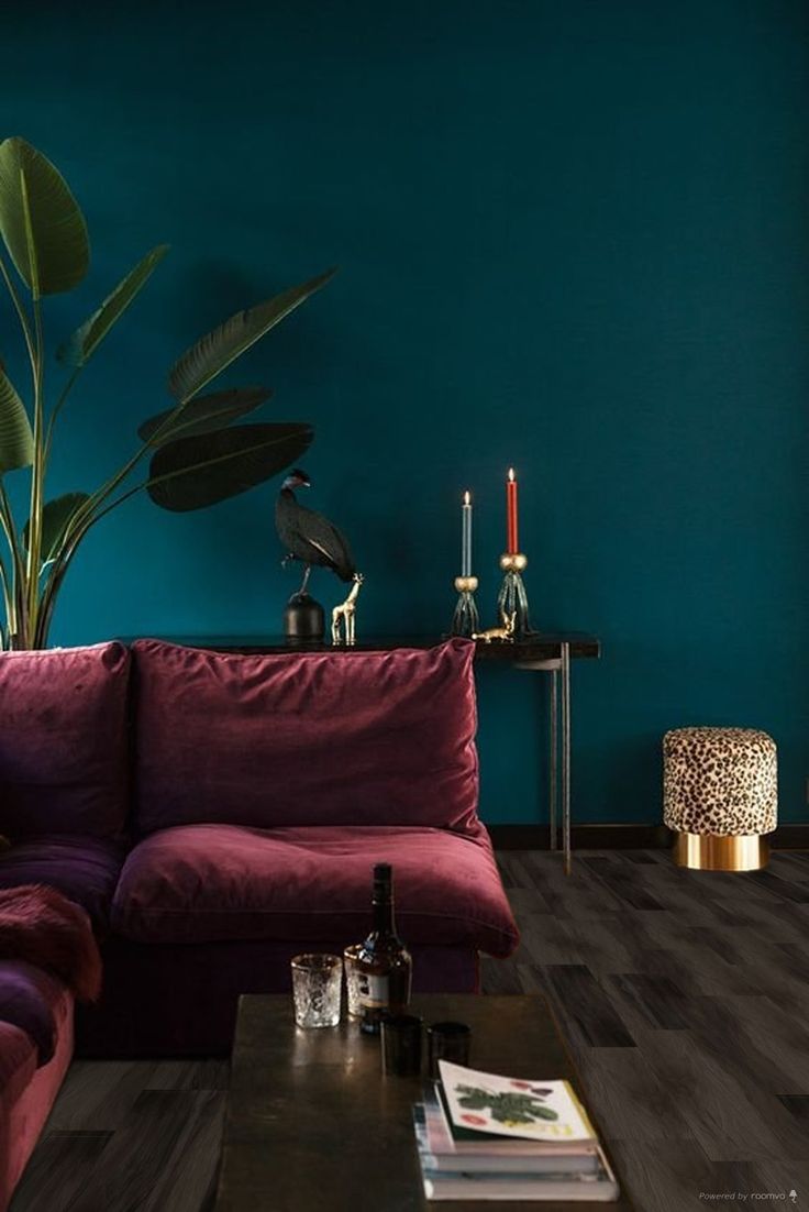 a living room with blue walls and purple couches in front of a coffee table