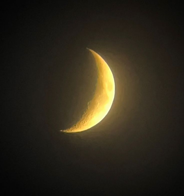 the moon is seen through the dark sky