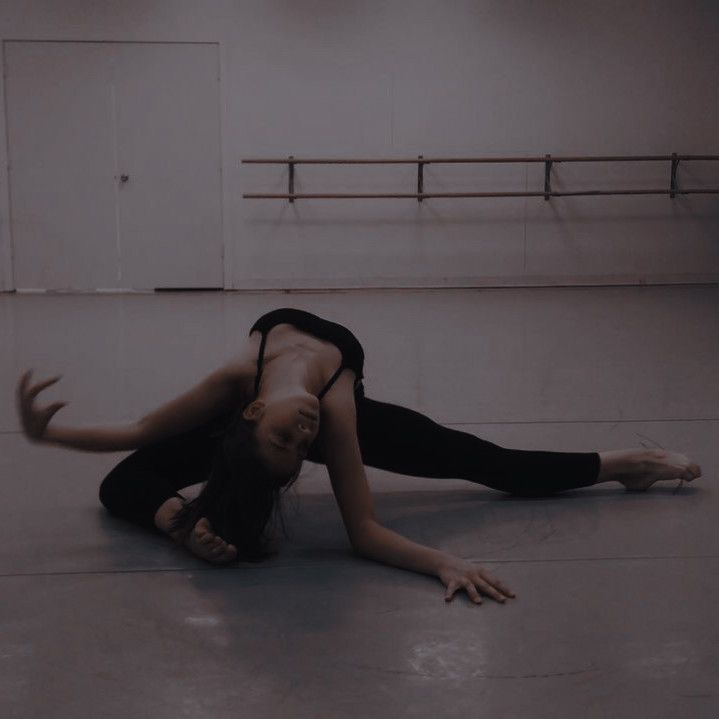 a woman in black shirt doing a handstand on the floor