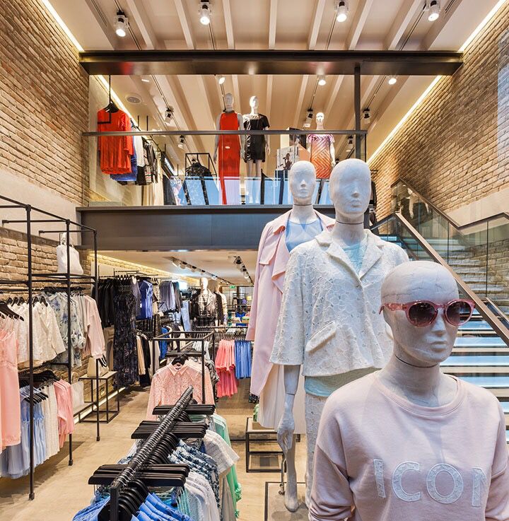 mannequins in front of clothing displayed on racks