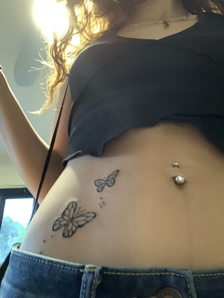 a woman with a butterfly tattoo on her stomach