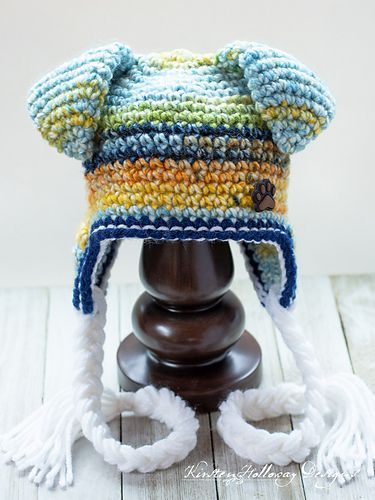 a crocheted hat on top of a wooden stand