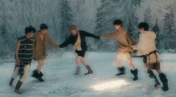 four young men are playing in the snow