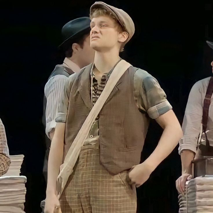 three men standing next to each other in front of stacks of folded up paper bags