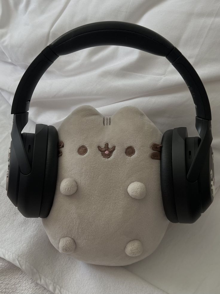 a stuffed animal wearing headphones on top of a bed