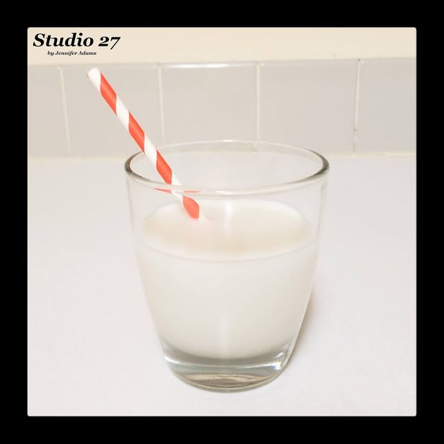 a glass filled with milk and a red and white striped straw