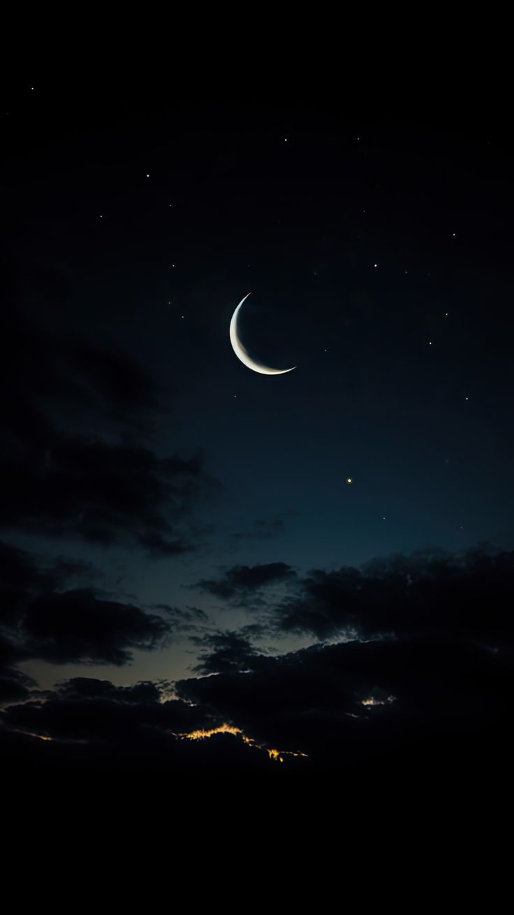 the moon and venus are seen in the night sky above some clouds on a dark, cloudy day