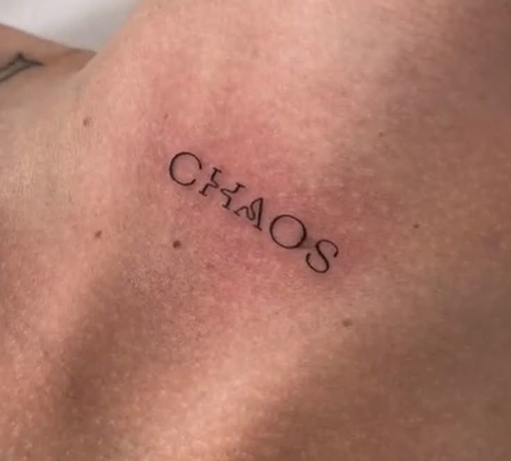 a man's chest with the word chaos written on it in cursive font