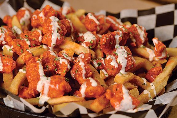 chicken and cheese fries in a basket on a table