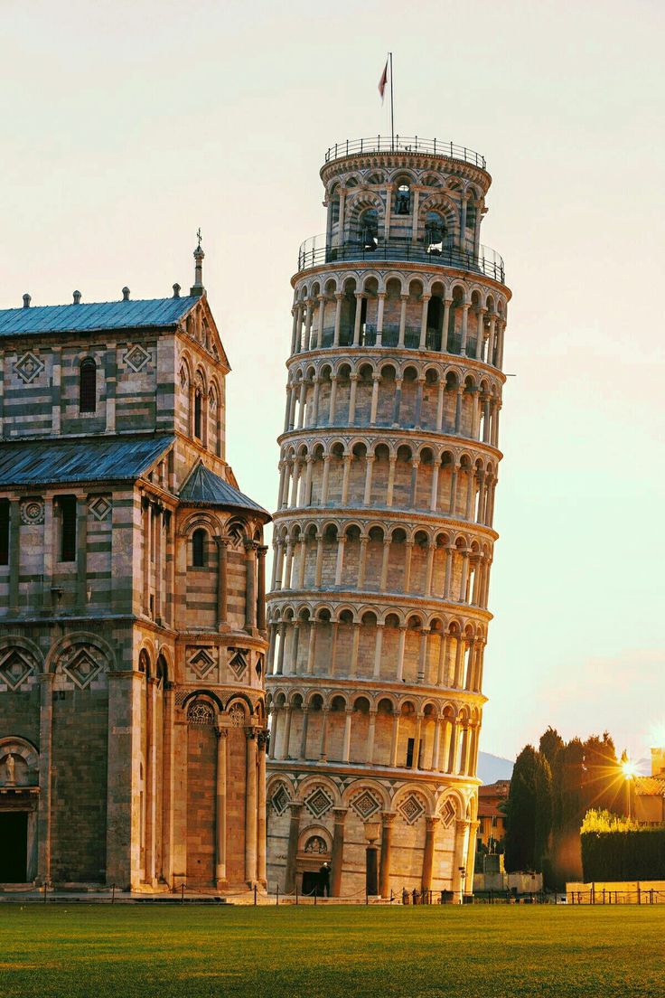 the leaning tower of pisa is lit up at sunset in front of an old building