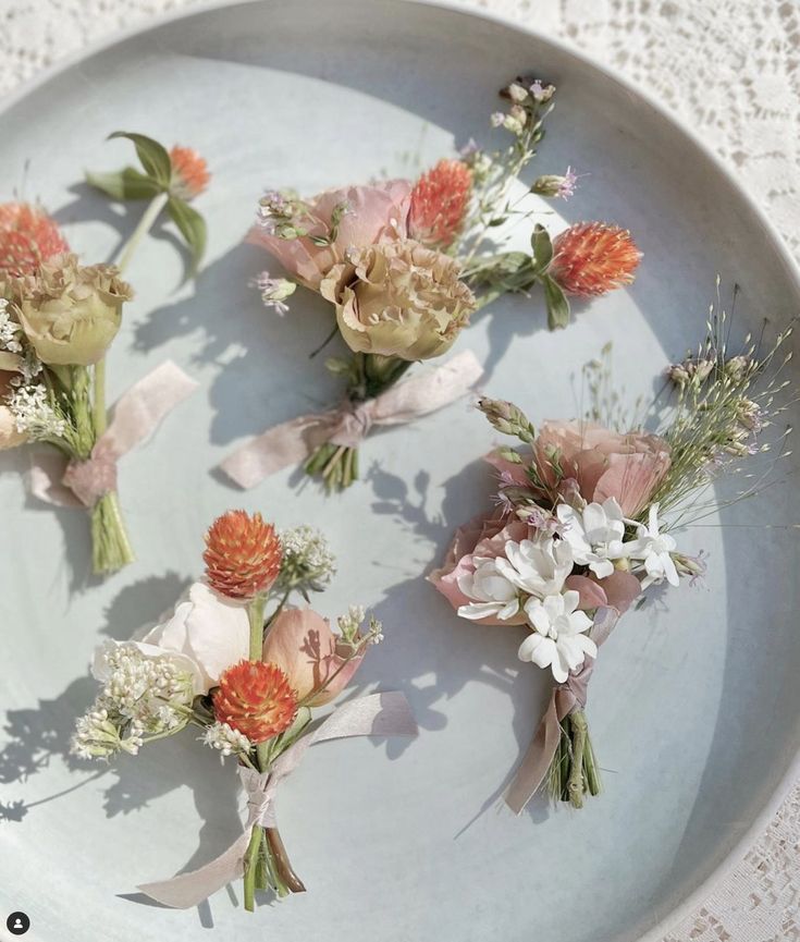 small bouquets of flowers are arranged on a plate